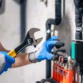 man-installs-heating-system-house-checks-pipes-with-wrench_169016-55822
